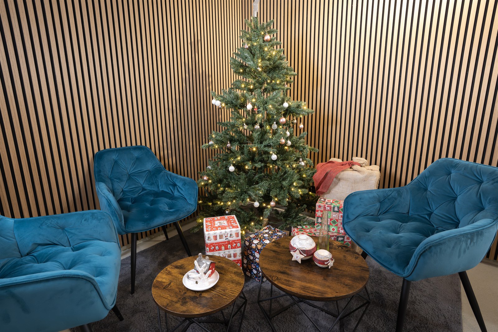 Loungeecke mit petrolblauen Samtsesseln vor dem geschmückten Weihnachtsbaum
