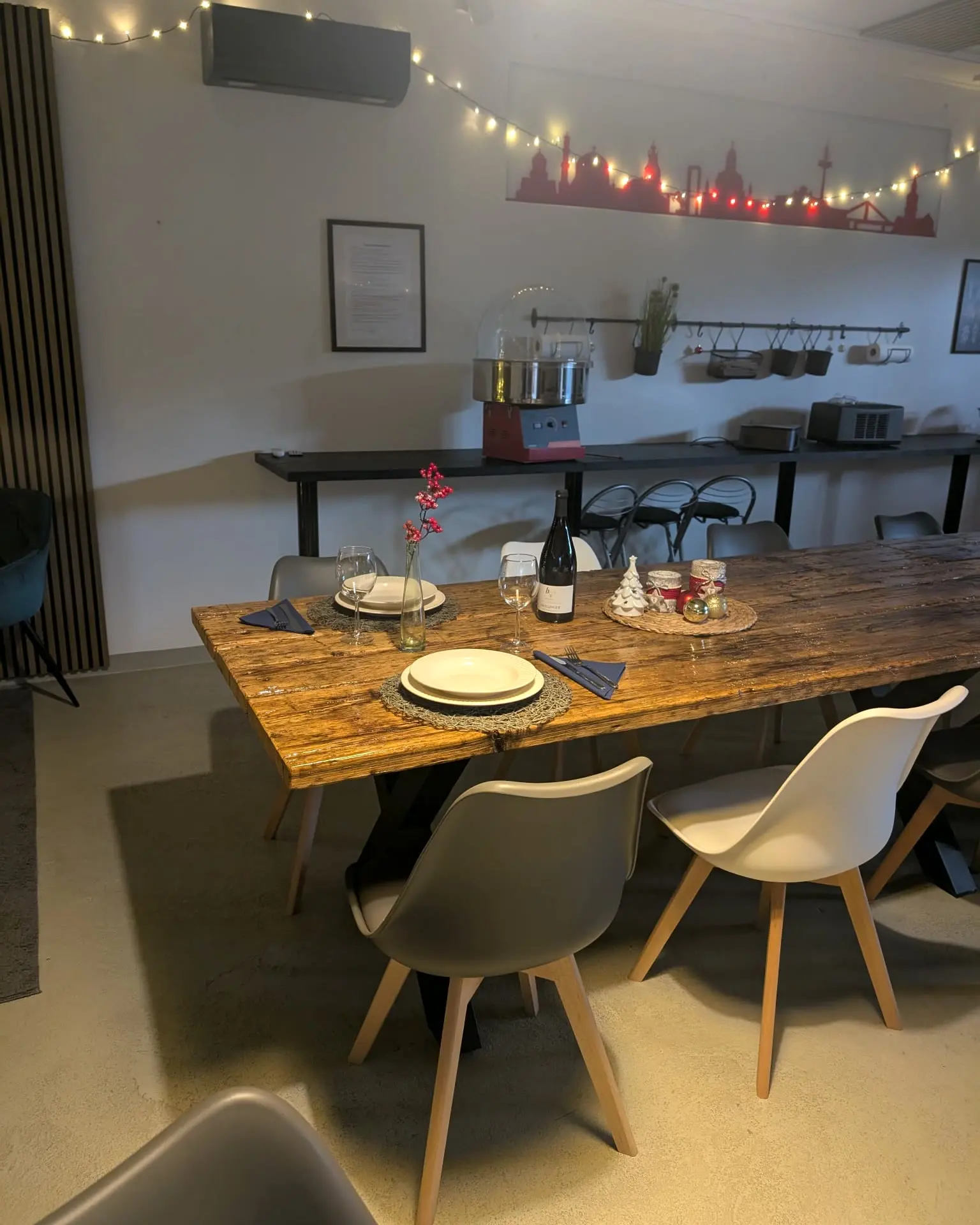 Für zwei Personen gedeckte Altholztafel mit Wein und Kerzen, im Hintergrund die beleuchtete Dresdner Skyline