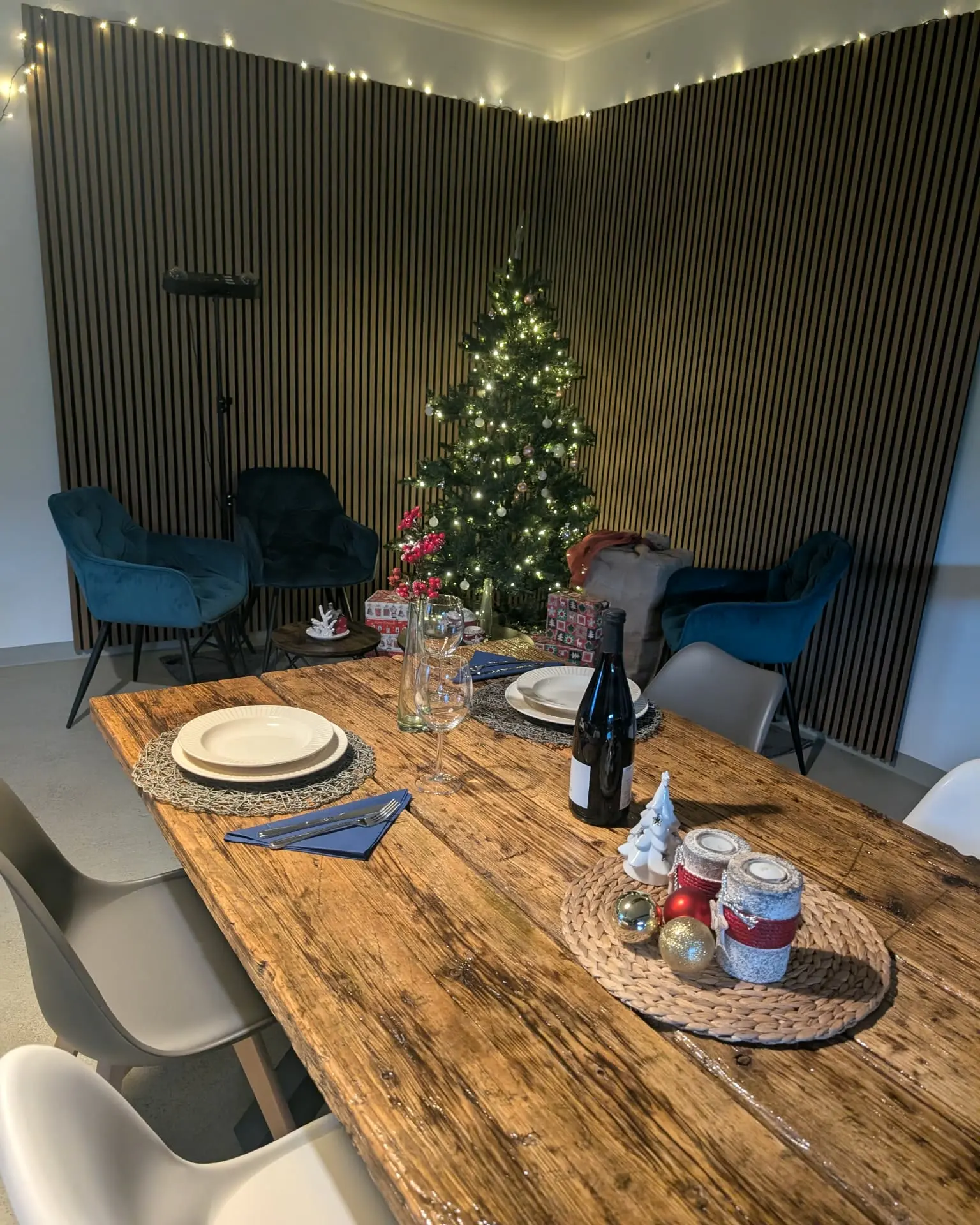 Festlich gedeckte Altholztafel mit Wein und Kerzen vor dem Weihnachtsbaum der Event-Küche Dresden