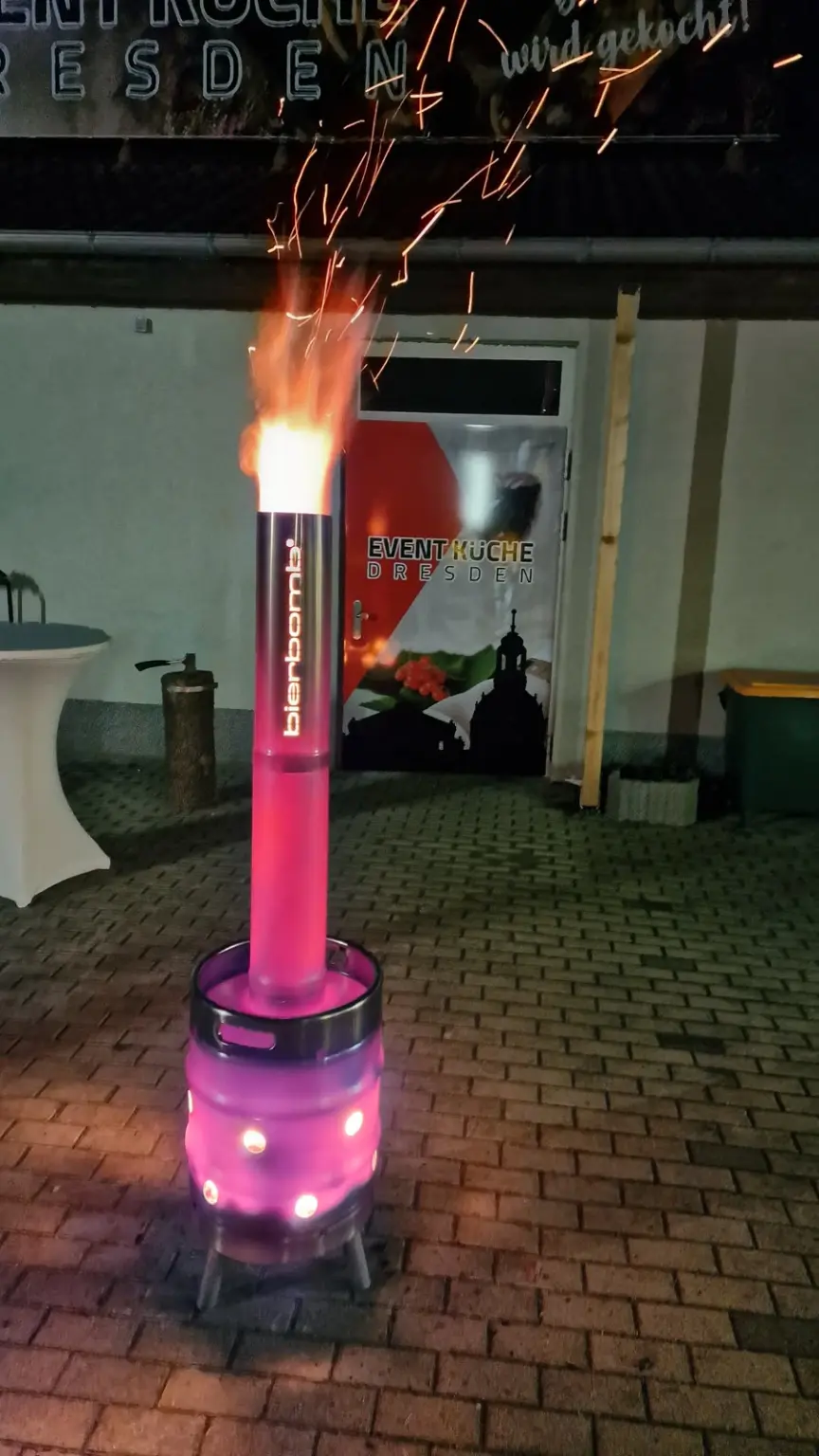 Die bierbomb Feuertonne brennt in der Dämmerung im Hof der Event-Küche Dresden, Funken steigen auf
